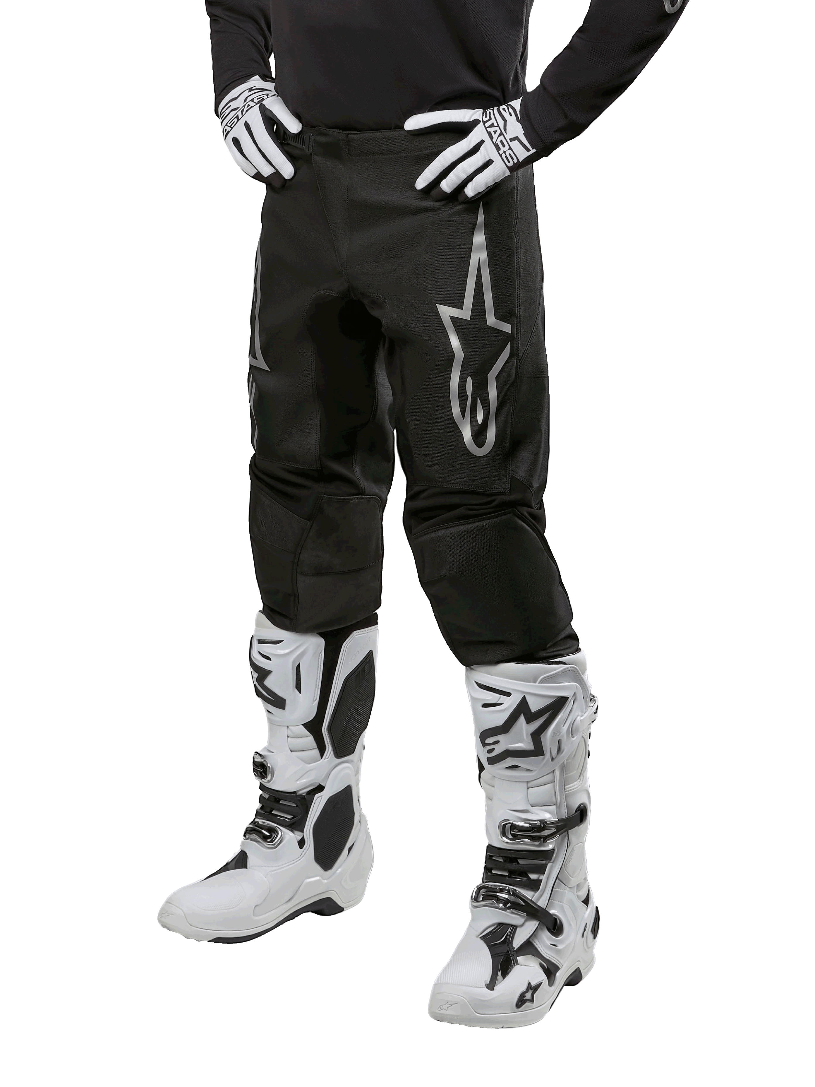 Alpinestars 2024 Fluid Graphite Pants, Motocross Pants, Gray and Black, worn with white and black motocross boots and gloves, featuring a large silver Alpinestars logo on the thigh, athletic sport fit for off-road riding