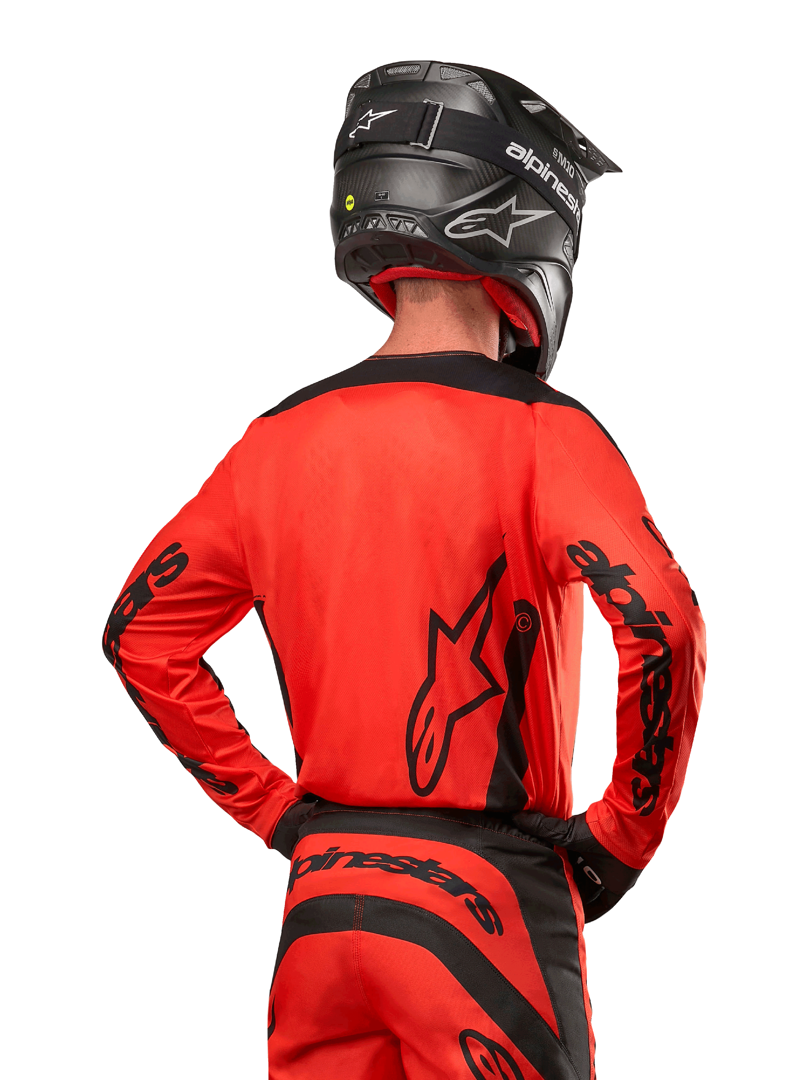 Motocross rider from behind wearing the Alpinestars 2024 Fluid Lurv Jersey in Hot Orange and Black, featuring bold Alpinestars branding on the back and sleeves, paired with matching motocross pants and a black helmet, designed for off-road racing performance.