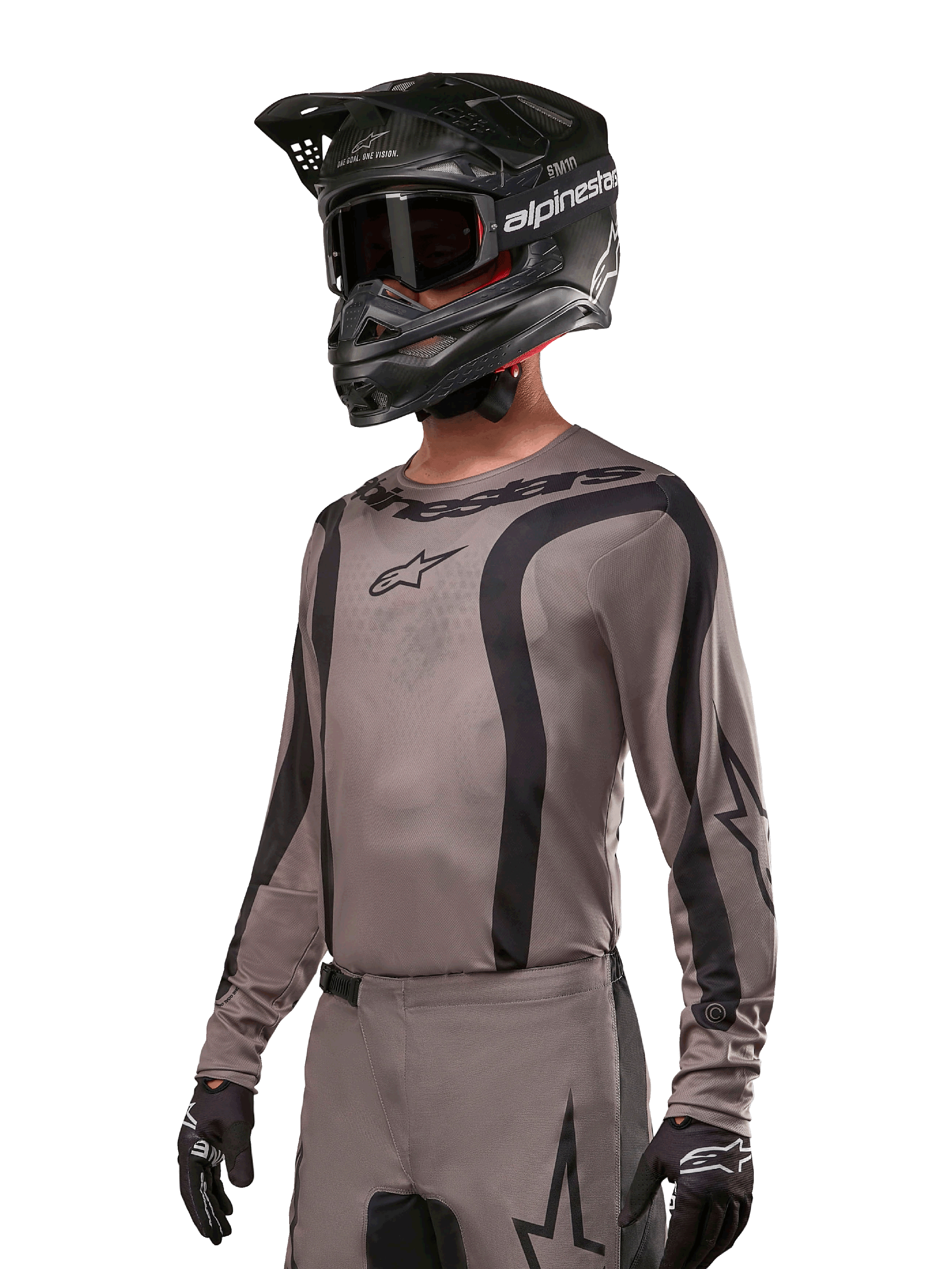 Alpinestars 2024 Fluid Lurv Jersey, Motocross Jersey, Mud Black and Gray, long-sleeve design with curved black stripes and logos, worn with matching pants and a black motocross helmet, coordinated off-road racing setup