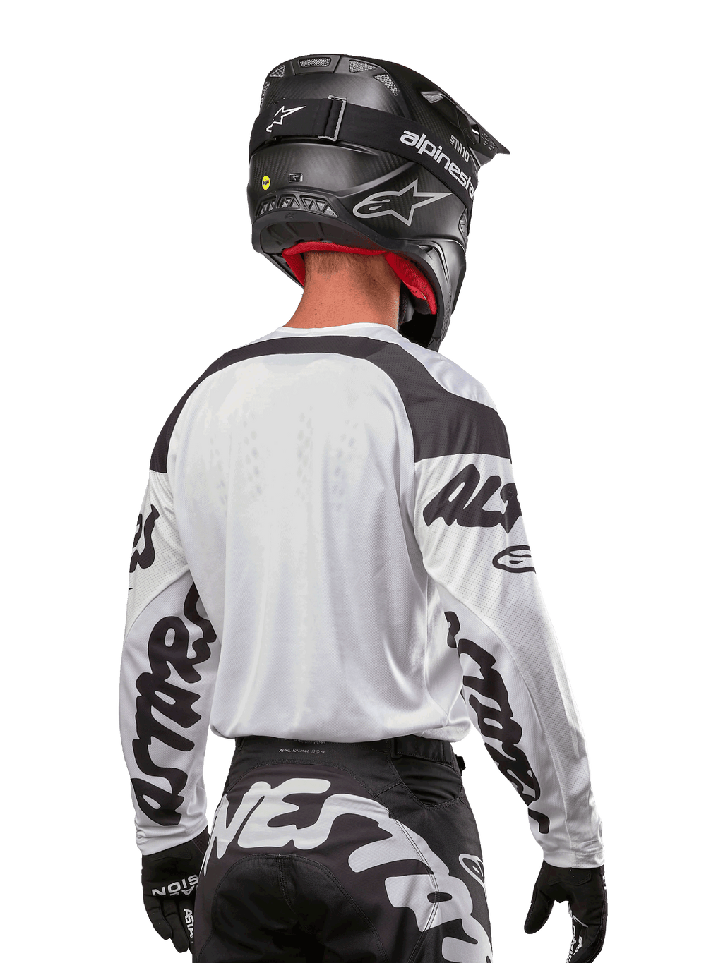 Alpinestars 2024 Racer Hana Jersey, White and Black, back view showing ergonomic fit and bold sleeve branding, paired with a black motocross helmet and matching black and white pants, high-performance racing gear for off-road riding