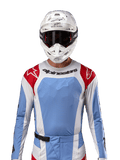 Alpinestars 2024 Techstar Ocuri Jersey, Motocross Racing Jersey, Light Blue Mars Red and White, front view featuring laser-cut ventilation and athletic fit, worn with a white helmet and goggles for a professional off-road racing look