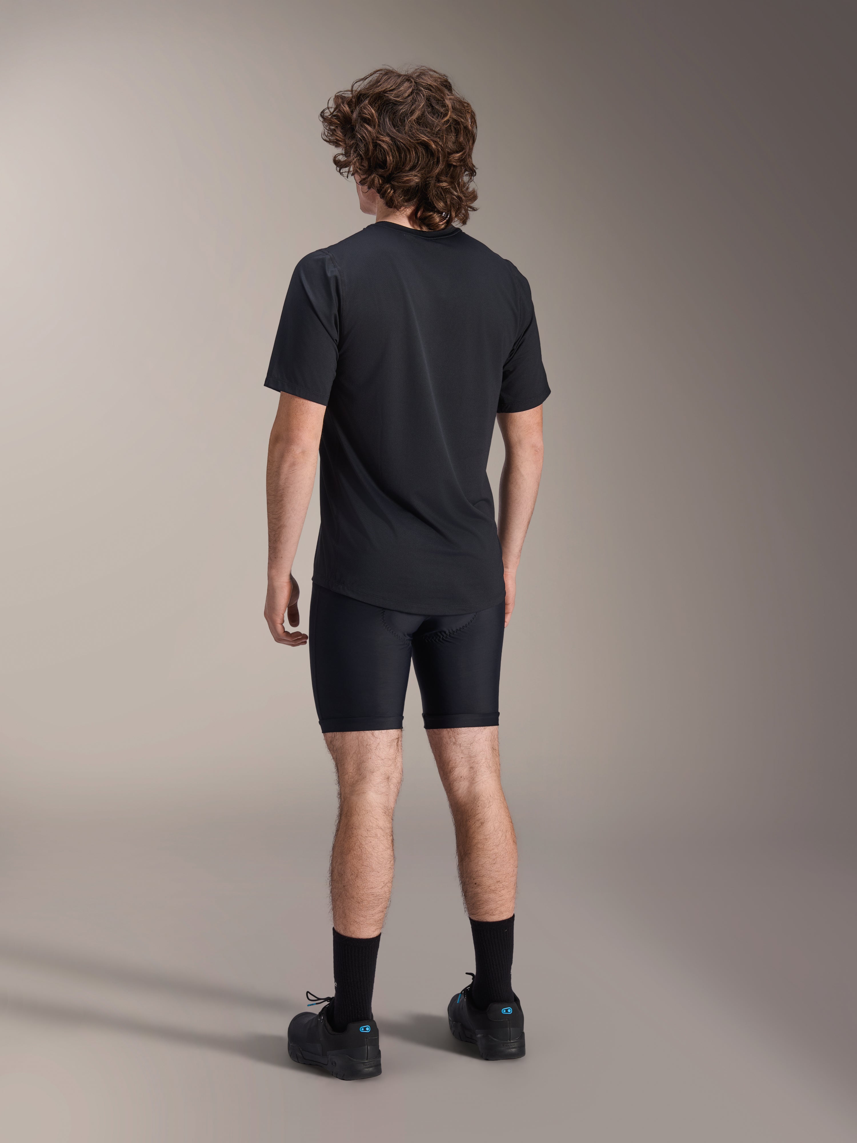 Alpinestars A-Dura Liner Shorts, Black Cycling Liner Shorts, back view on model, tight-fitting stretch fabric with visible chamois padding seams, paired with a black t-shirt and cycling shoes, mountain bike apparel