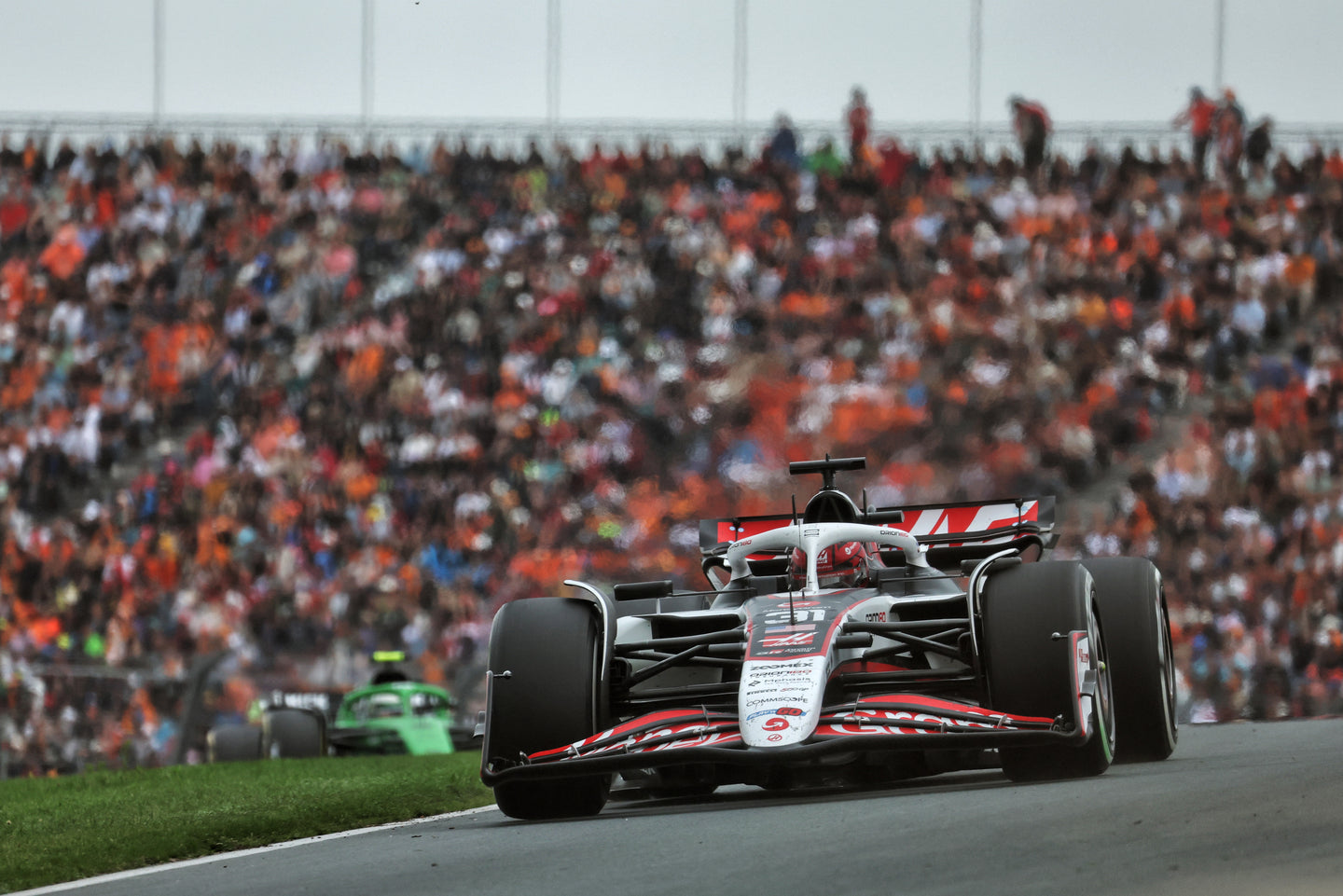 Esteban Ocon in his Haas Formula 1 car during a race, with blurred background