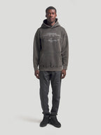 Alpinestars Infinite Washed Oversized Hoodie, Unisex Sportswear Pullover in Washed Black, featuring a premium snow-wash finish, front kangaroo pocket, and white embroidered brand wordmarks on the chest and hood for a vintage lifestyle look.