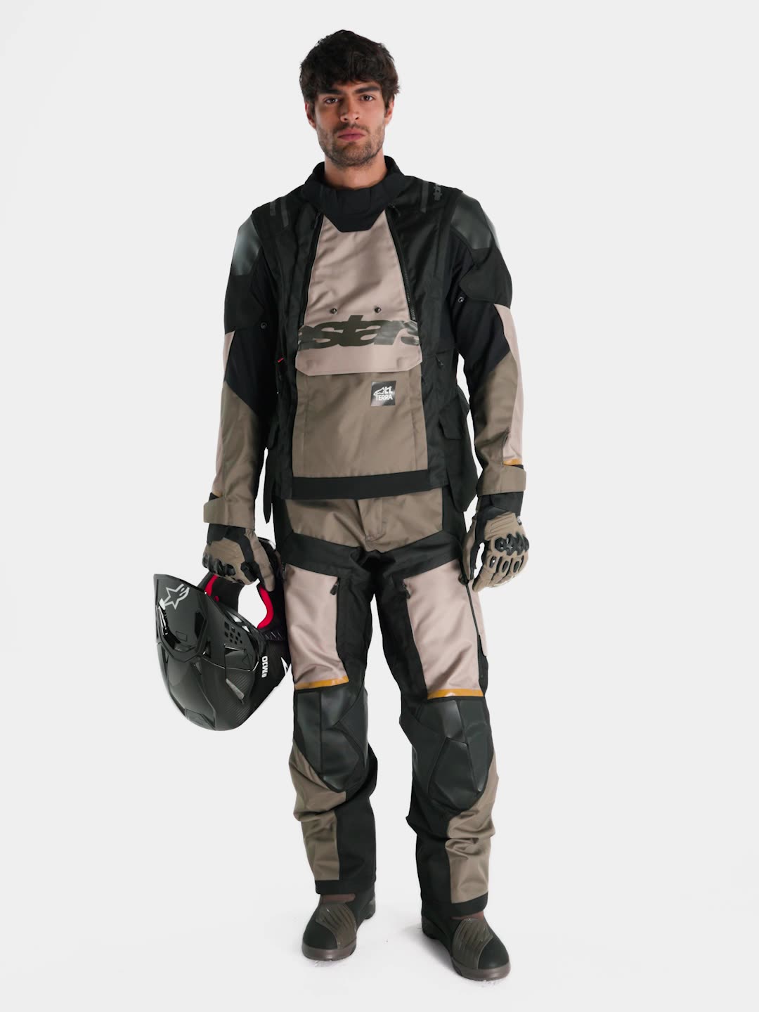 Alpinestars Harok V2 Drystar Jacket, men's adventure touring motorcycle jacket in aluminum, walnut, and black, full-body view of a model wearing matching textile gear and helmet holding off-road gloves.